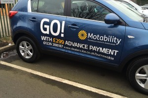 car dealer forecourt with lettering on the side of a car
