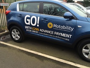 car dealer forecourt with lettering on the side of a car