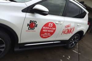 white car with promotional charity graphics