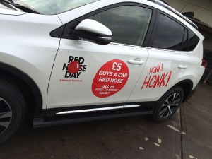 white car with promotional charity graphics