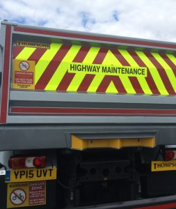 The rear view of a highway maintenance lorry with reflective safety graphics